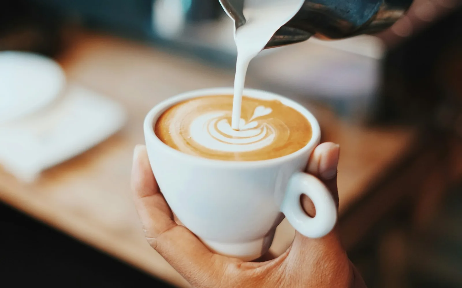 Barista sirviendo un café con arte latte