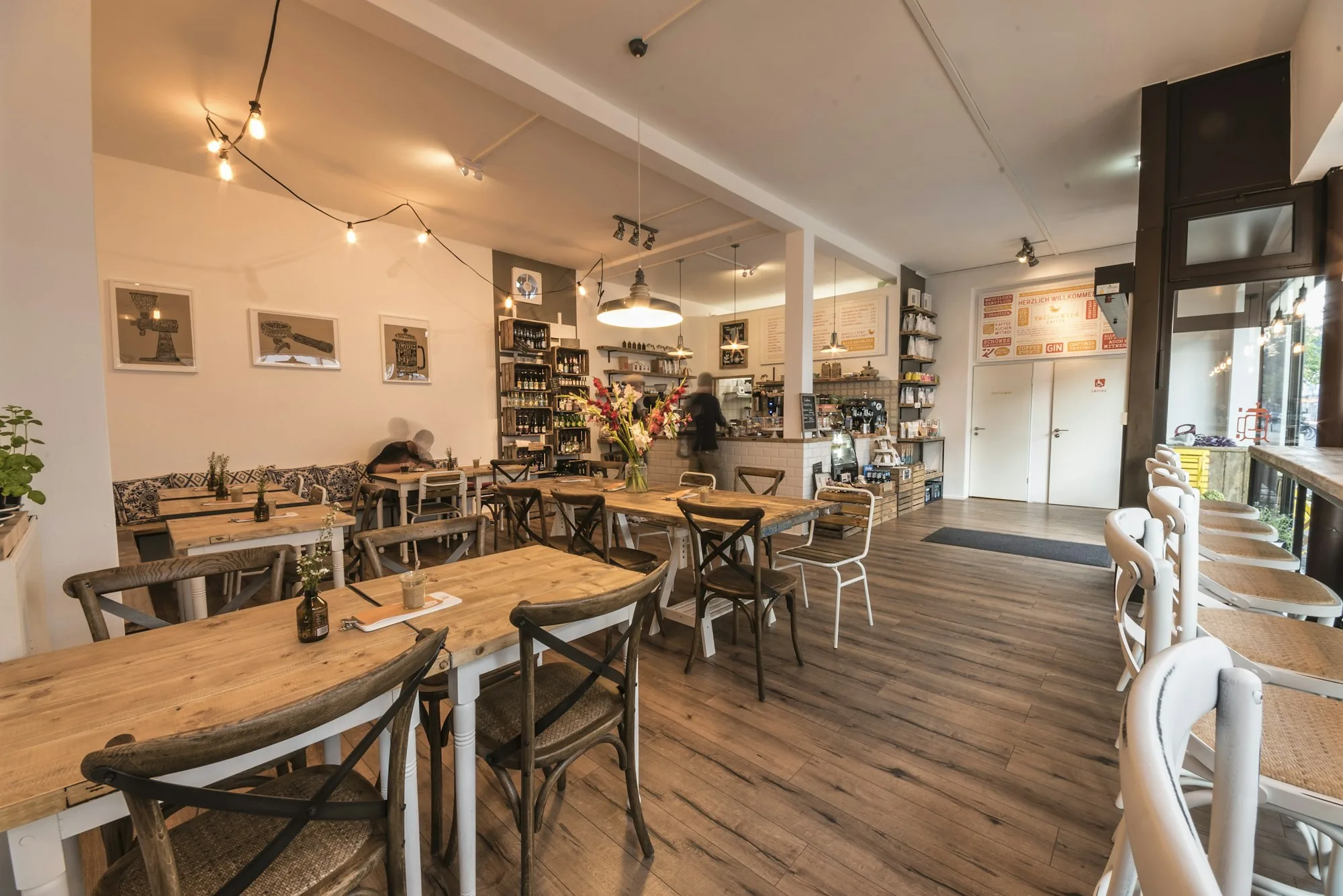 Interior de la cafetería con mesas de madera y luz natural